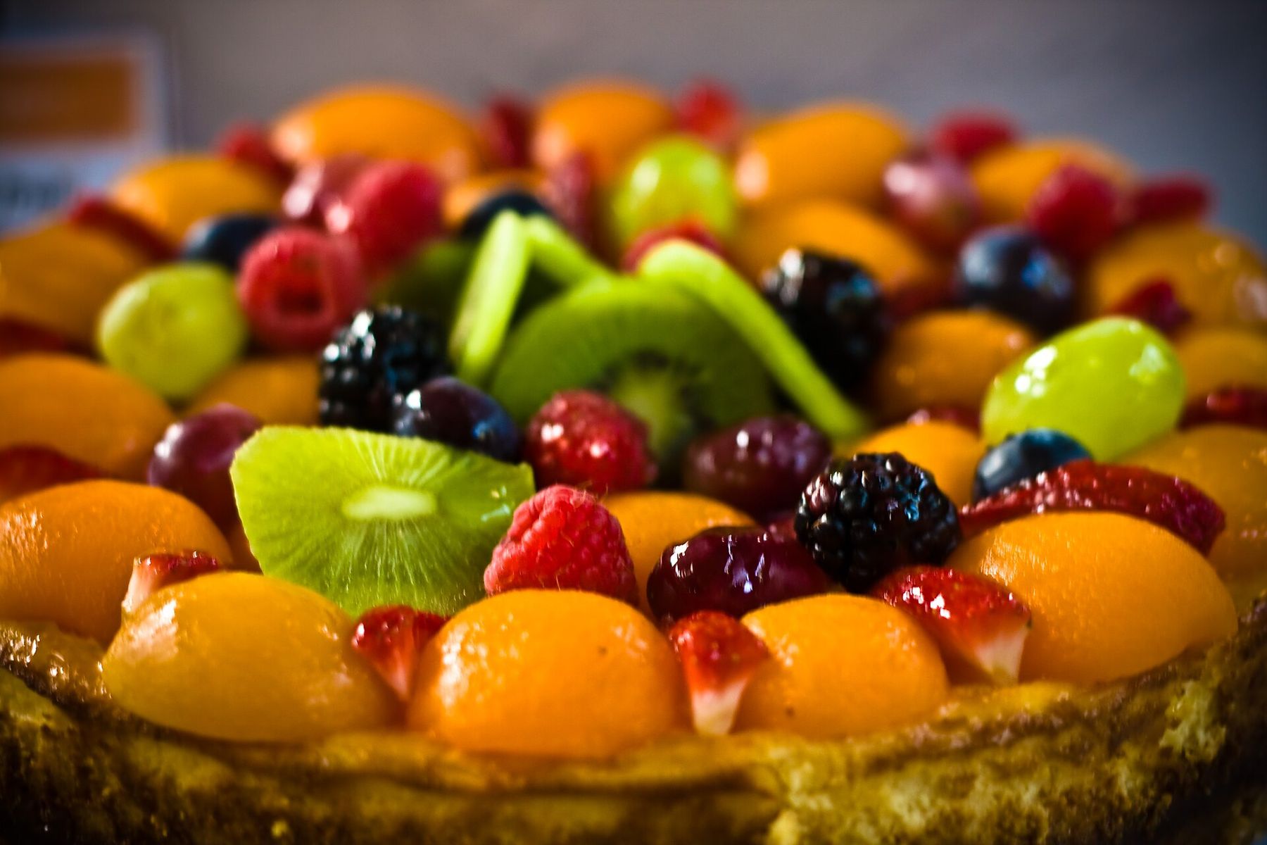 Une tarte aux fruits frais : kiwi, fraises, raisins, pêche et framboises